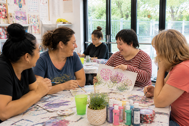 Support worker and participant enjoying coffee at local café